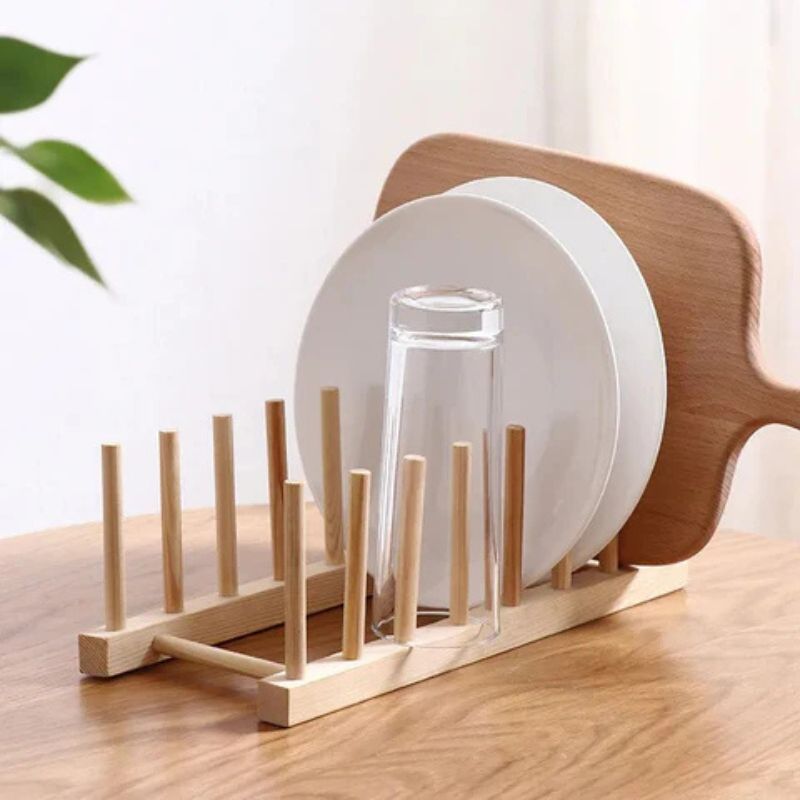 A bamboo dish rack with multiple compartments, placed on a kitchen countertop.