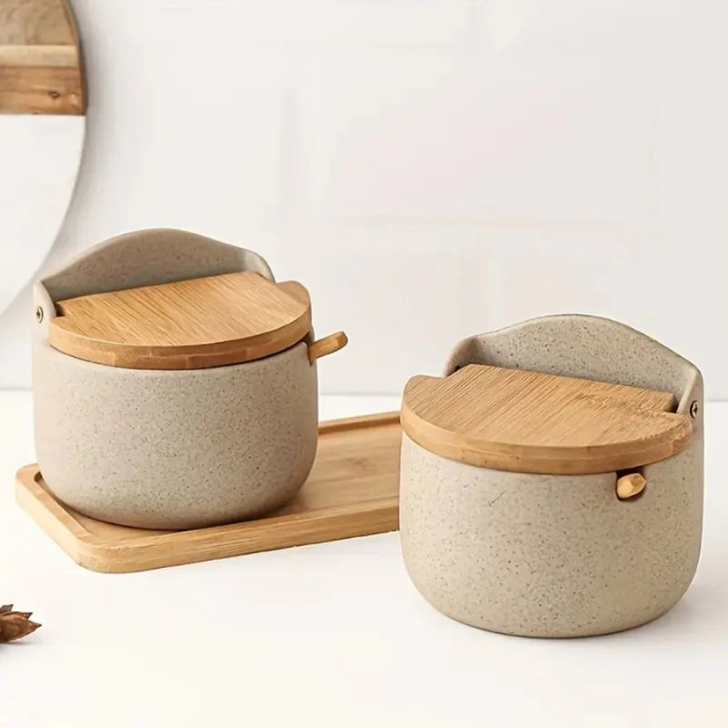 A set of ceramic bamboo spice pots with bamboo lids on a white background, displayed on a wooden tray.