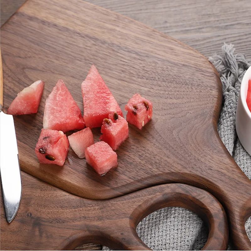 round-handled wooden cutting board with sliced watermelon