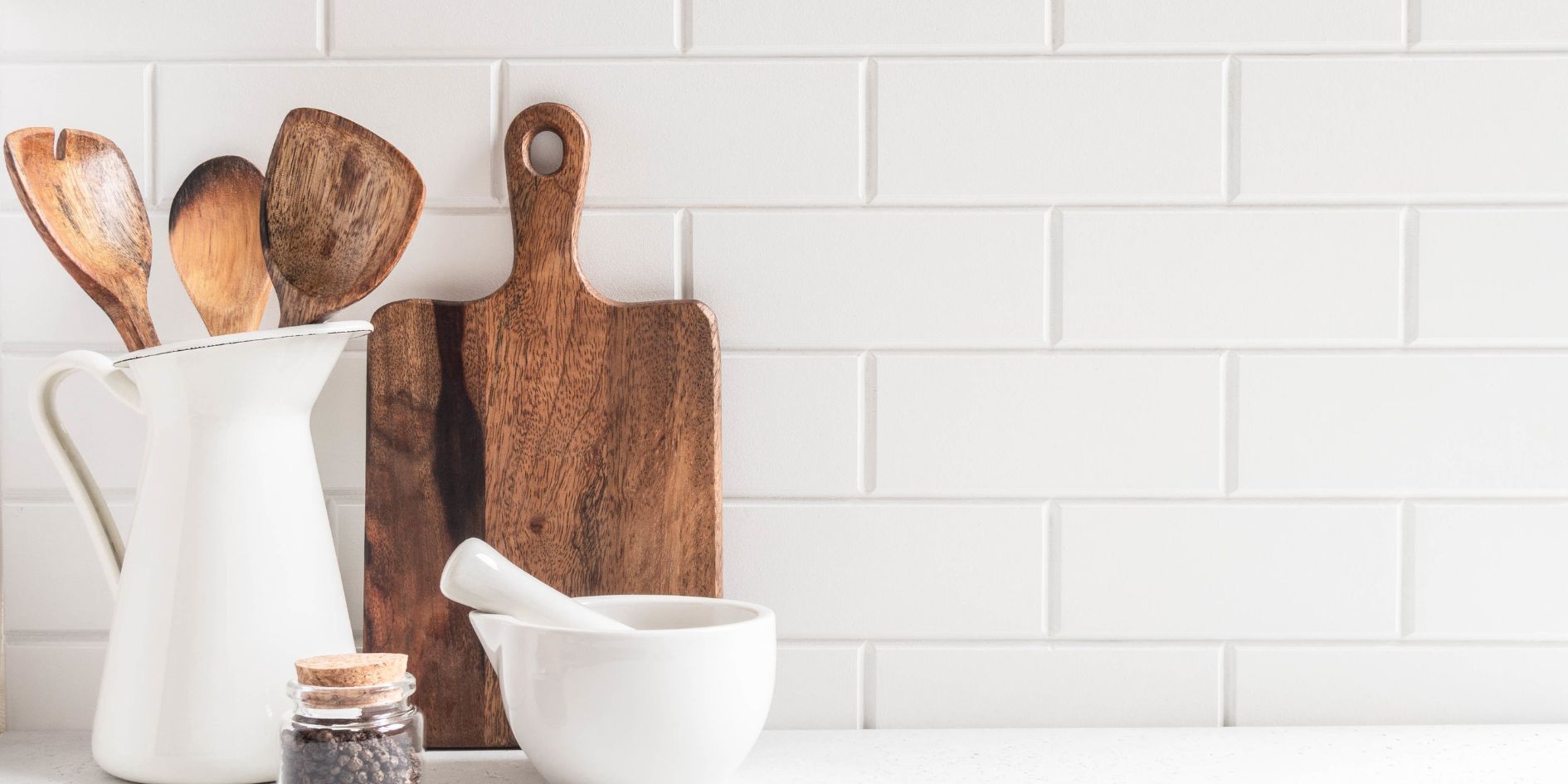 A neat kitchen counter with wooden kitchen tools.