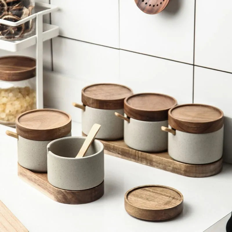 Set of ceramic containers with wooden lids on a kitchen counter.